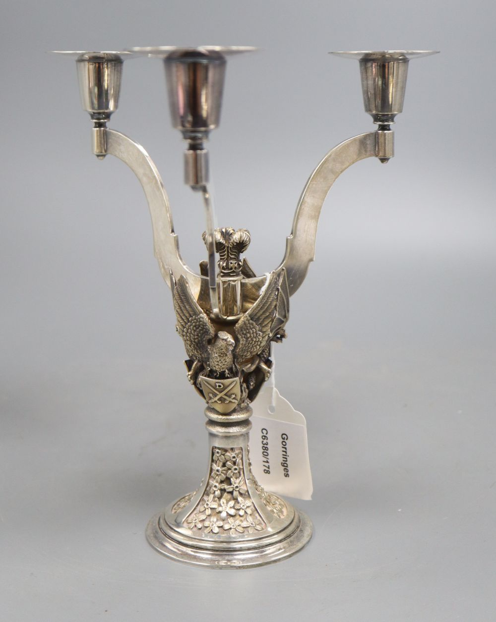 A silver parcel gilt three branch candelabra, shaped arms, on rampant bat,